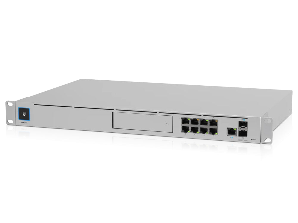 Foto van een Ubiquiti UniFi Dream Machine SE, een zilverkleurig, rechthoekig netwerkapparaat met het Ubiquiti-logo en meerdere aansluitpoorten aan de voorkant. Het apparaat ligt op een witte achtergrond, wat de aandacht vestigt op het strakke en moderne ontwerp.